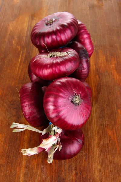 Cipolle rosse fresche su fondo di legno — Foto Stock