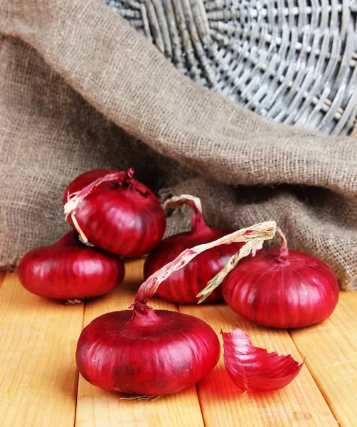 Cebollas rojas frescas sobre mesa de madera —  Fotos de Stock