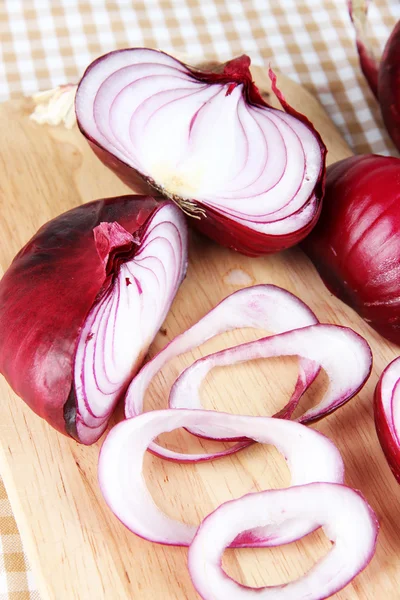 Fresh red onions on cutting board close up — Stock Photo, Image