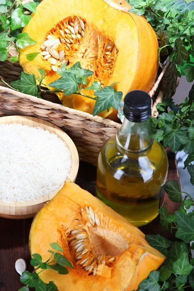 Cut pumpkin with ingredients for cooking on wooden table on natural background — Stock Photo, Image