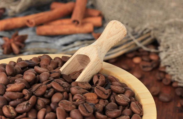 Grãos de café em tigela no fundo de madeira — Fotografia de Stock