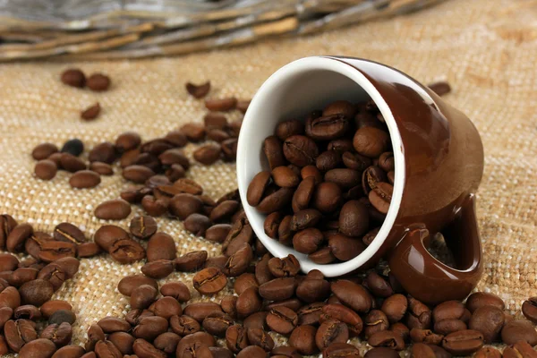 Kaffeebohnen in Tasse auf dem Tisch in Großaufnahme — Stockfoto