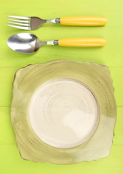 Plate and cutlery on wooden table close-up — Stok fotoğraf