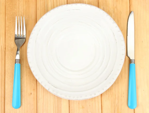 Plate and cutlery on wooden table close-up — Stockfoto