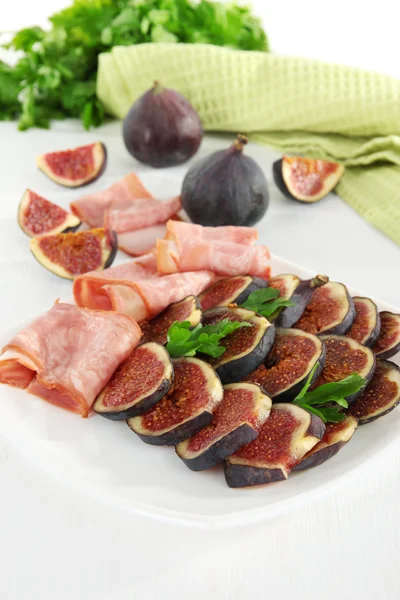 Smakelijke vijgen met ham op witte houten tafel — Stockfoto