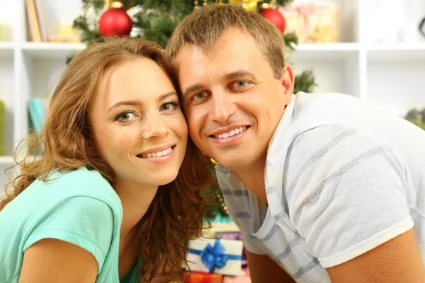 自宅のクリスマス ツリーの近く幸せな若いカップル — ストック写真