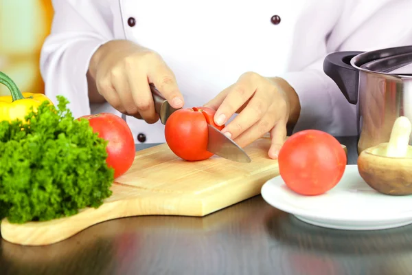 Mãos de cozinheiro corte de tomate — Fotografia de Stock