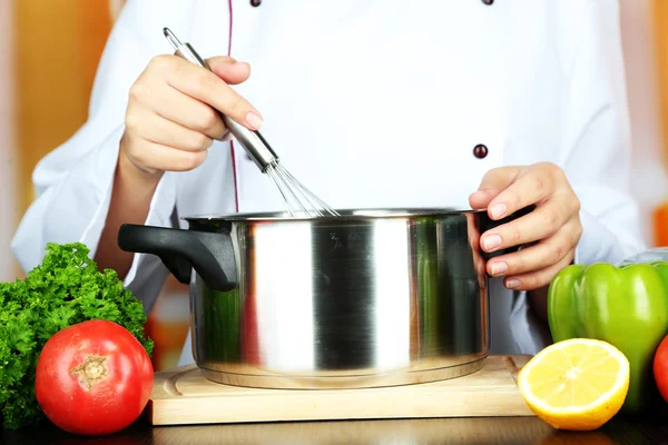 Cuire les mains et la casserole sur le lieu de travail — Photo