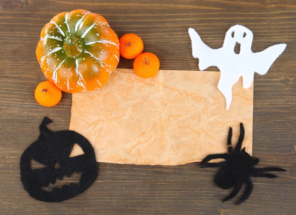 Old paper with Halloween decorations on grey wooden background — Stock Photo, Image