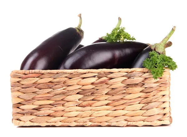 Verse aubergines in rieten mand geïsoleerd op wit — Stockfoto