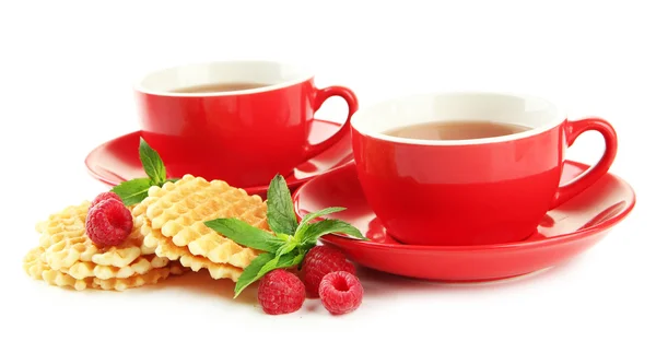 Tazas de té con galletas y frambuesas aisladas en blanco — Foto de Stock