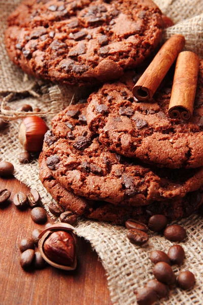 Homemade cookies with sesame seeds, chocolate, on wooden table, on sackcloth background — Stock Photo, Image