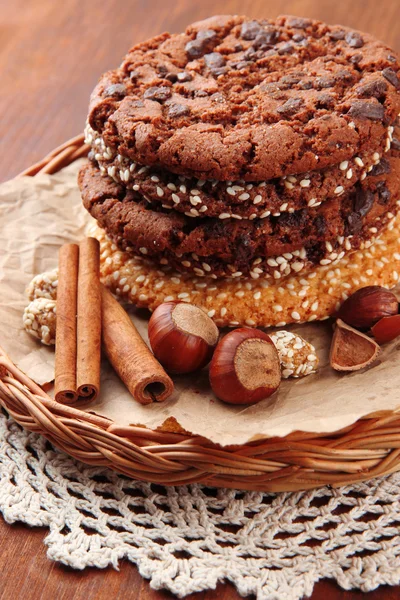Biscotti fatti in casa con semi di sesamo, cioccolato, su tovagliolo, su sfondo di legno — Foto Stock