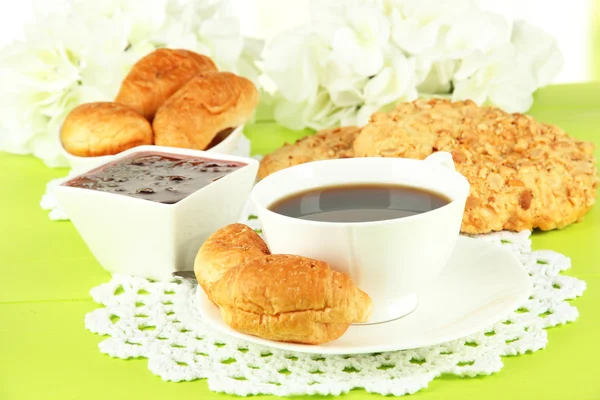 Croissant gustosi e una tazza di caffè in tavola primo piano — Foto Stock