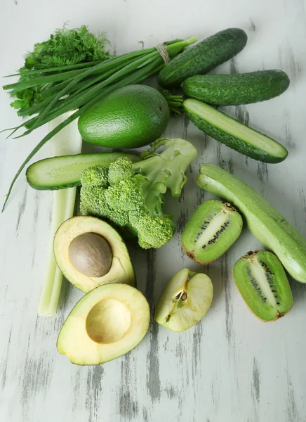 Свежие зеленые овощи и фрукты на деревянном фоне — стоковое фото