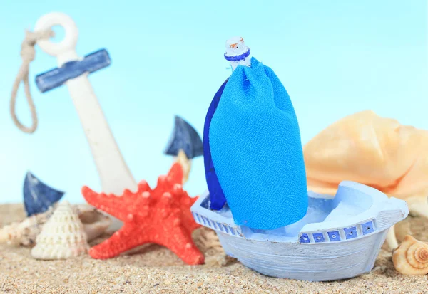 Blaues Spielzeugschiff auf Sand, auf blauem Hintergrund — Stockfoto