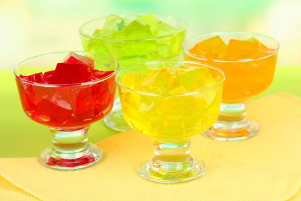 Tasty jelly cubes in bowls on table on light background — Stock Photo, Image