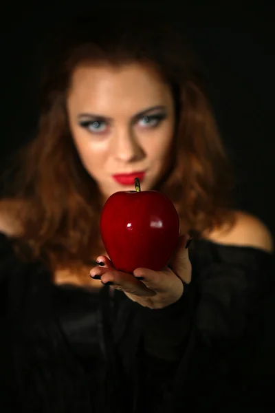 Halloween heks met apple op donkere achtergrond — Stockfoto