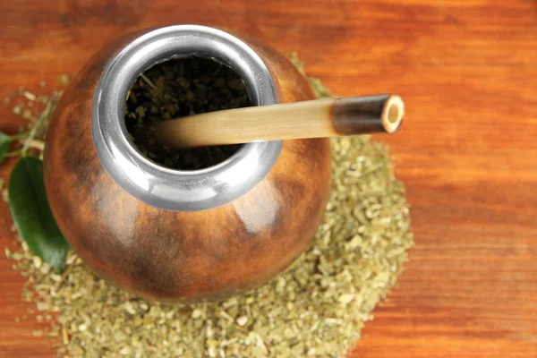 Calabash and bombilla with yerba mate on wooden background — Stock Photo, Image