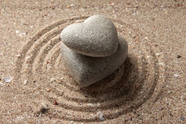 Gri zen stone kum arka plan üzerinde kalp şeklinde