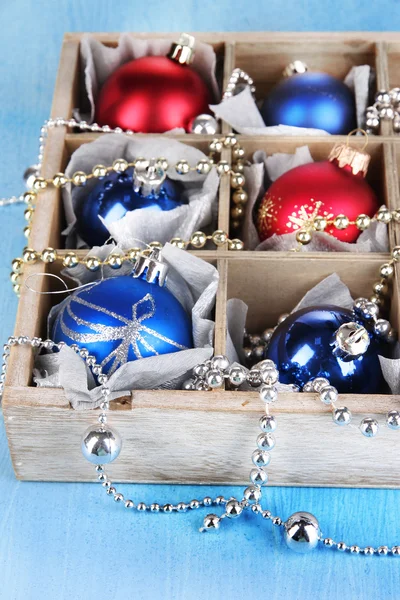 Christmas toys in box on wooden table close-up — Stock Photo, Image