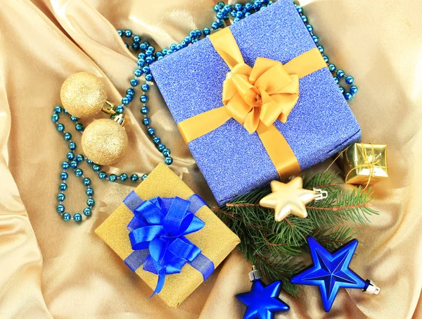 Hermosos regalos brillantes y decoración de Navidad, en tela de seda — Foto de Stock