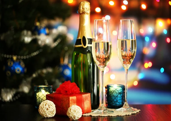 Glasses of champagne and gifts on bright background — Stock Photo, Image