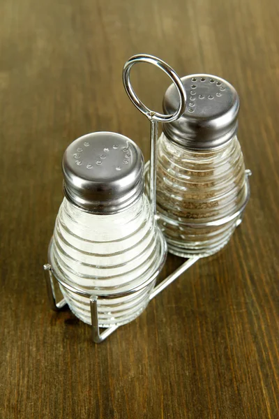 Salt and pepper mills, on wooden background — Stock Photo, Image