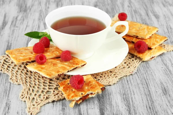 Tasse Tee mit Keksen und Himbeeren auf dem Tisch in Großaufnahme — Stockfoto