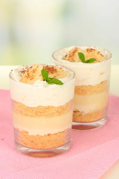 Delicious dessert with banana and caramel on table on light background — Stock Photo, Image