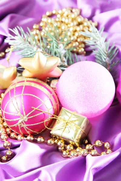 Красивый рождественский декор на фиолетовой атласной ткани — стоковое фото