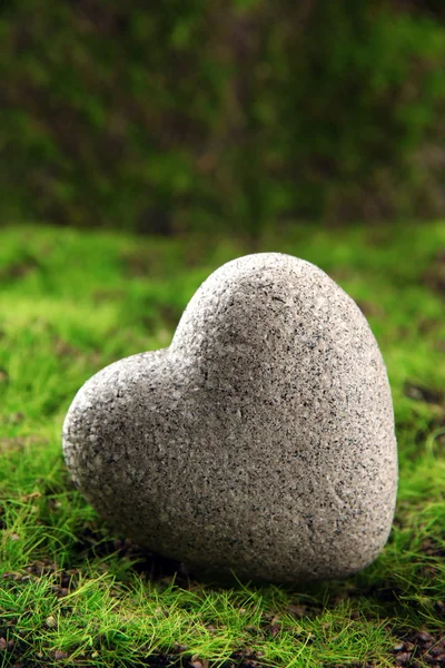 Piedra gris en forma de corazón, sobre fondo de hierba —  Fotos de Stock