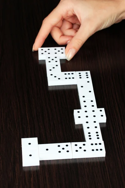 Mão jogar dominó no fundo de madeira — Fotografia de Stock