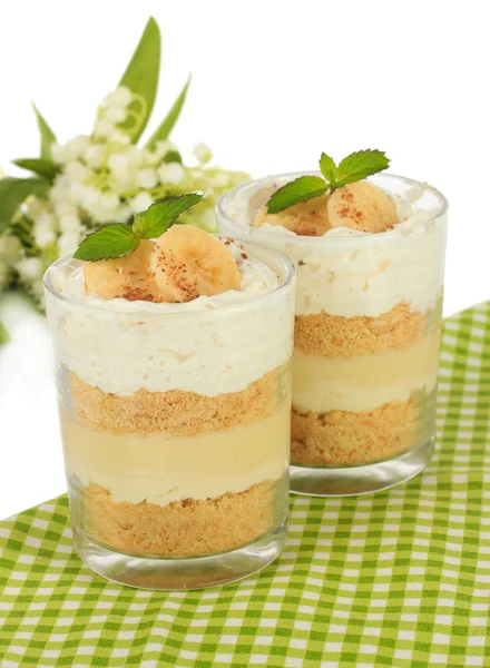 Deliciosa sobremesa com banana e caramelo na mesa sobre fundo branco — Fotografia de Stock