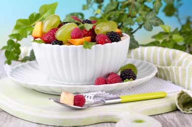 parlak zemin üzerine ahşap masa üzerinde kase meyve salatası