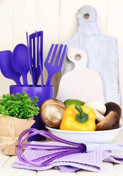 Ustensiles de cuisine en plastique dans une tasse sur une table en bois — Photo