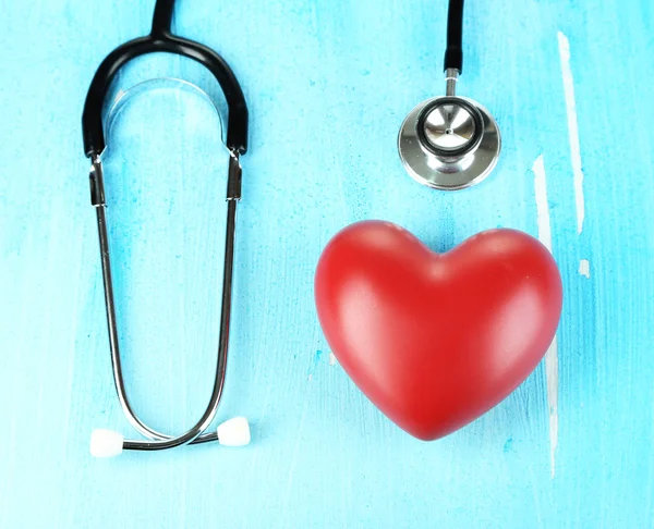 Stethoscope and heart on wooden table close-up — Stock Photo, Image