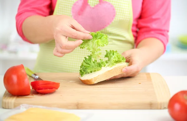 Счастливая улыбающаяся женщина на кухне готовит сэндвич, закрывается — стоковое фото