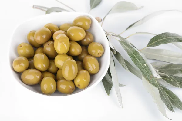 Olive in ciotola con ramo isolato su bianco — Foto Stock