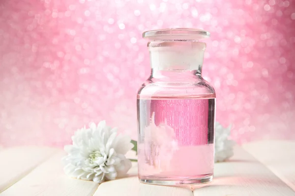 Pembe bir arka plan üzerinde renkli özü ile cam şişe — Stok fotoğraf
