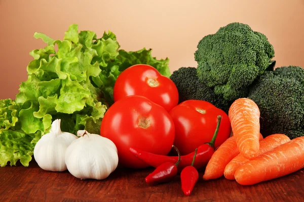 Composition of different vegetables on wooden table on brown background — Stock Photo, Image