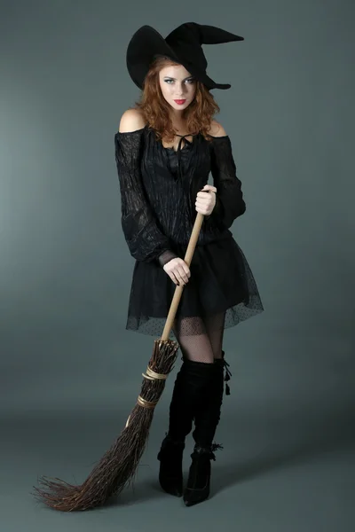 Halloween witch with broom on gray background — Stock Photo, Image