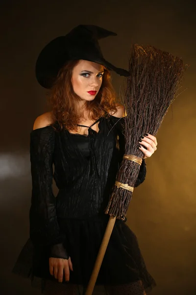 Halloween witch with broom on dark background — Stock Photo, Image