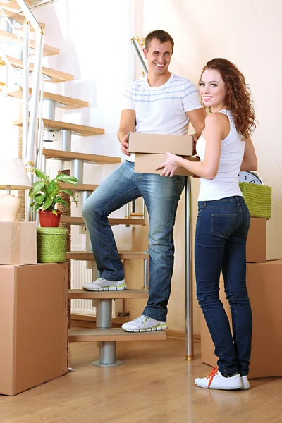 Young couple with boxes in new home on staircase — Stock Photo, Image