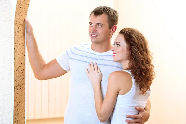 Pareja joven en casa nueva en el fondo de la habitación — Foto de Stock