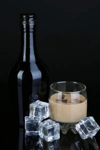 Baileys liqueur in bottle and glass isolated on black — Stock Photo, Image