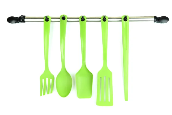 Plastic kitchen utensils on silver hooks isolated on white — Stock Photo, Image