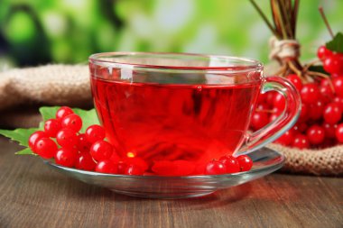Bodegón con té de viburnum en servilleta de tela de saco, sobre fondo de madera