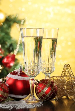 Yılbaşı süsleri ve parlak zemin üzerine iki şampanya bardağı kompozisyonu