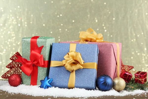 Schöne helle Geschenke und Weihnachtsdekoration, auf glänzendem Hintergrund — Stockfoto